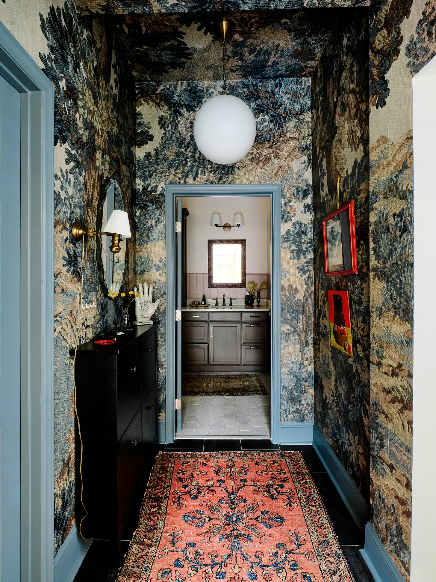 Moody entryway with wallpaper and blue trim