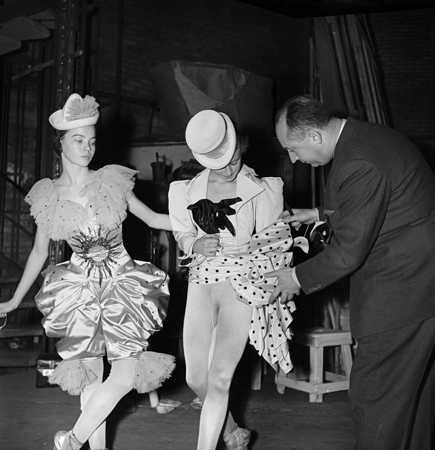 At the Théâtre des Champs Elysées, a 16-year-old Leslie Caron watches Dior make last-minute changes to the costume of Nelly Guillerm, for Roland Petit’s ballet "Les Treize Danses." © Roger-Viollet. Image courtesy Dior