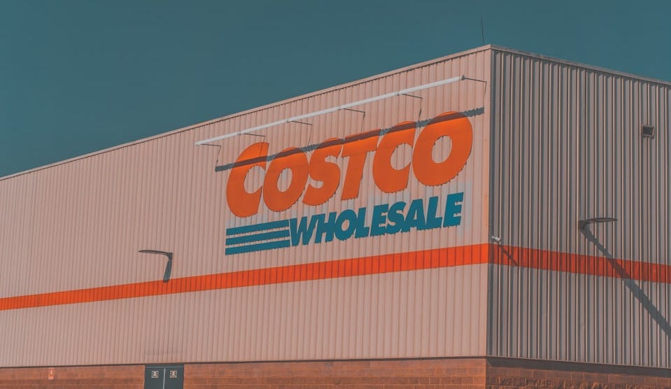 a building with a sign that says costco whole sale a building with a sign that says costco whole sale