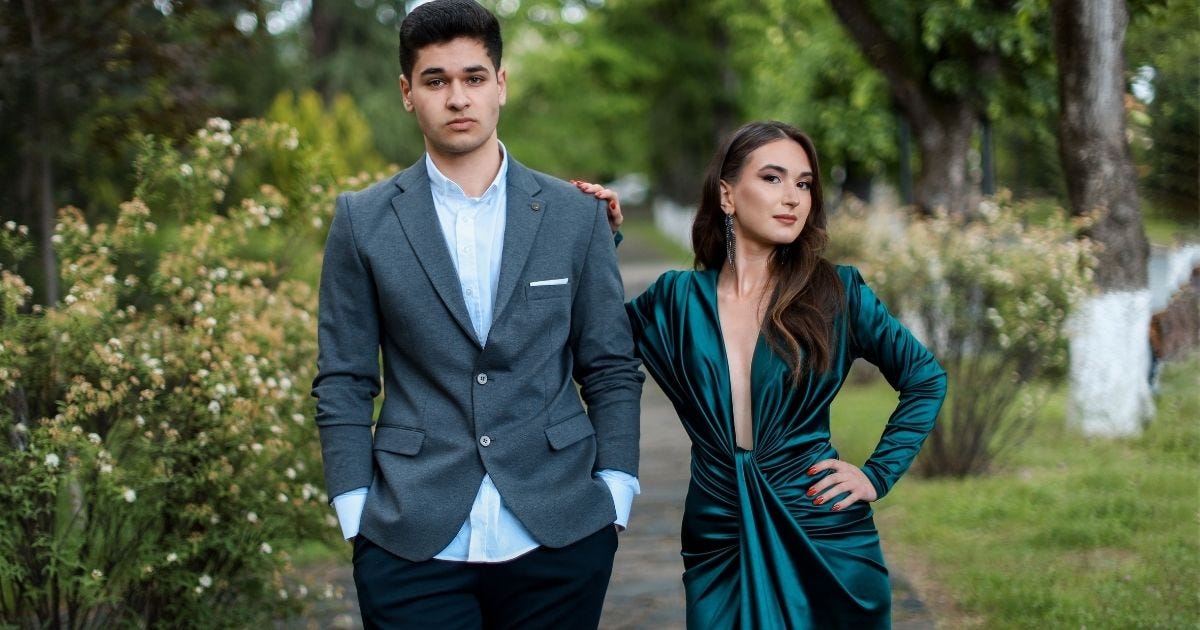 Stylish couple in formal attire striking a pose outdoors amidst lush greenery Stylish couple in formal attire striking a pose outdoors amidst lush greenery