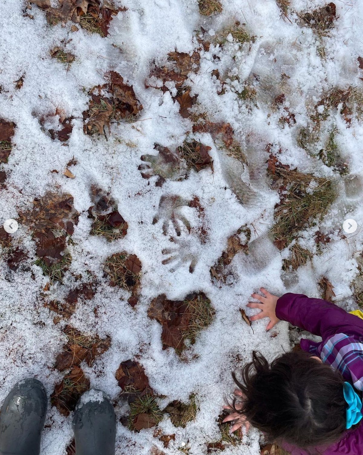 children's handprints on the icy snow and a child putting their hand in the ice