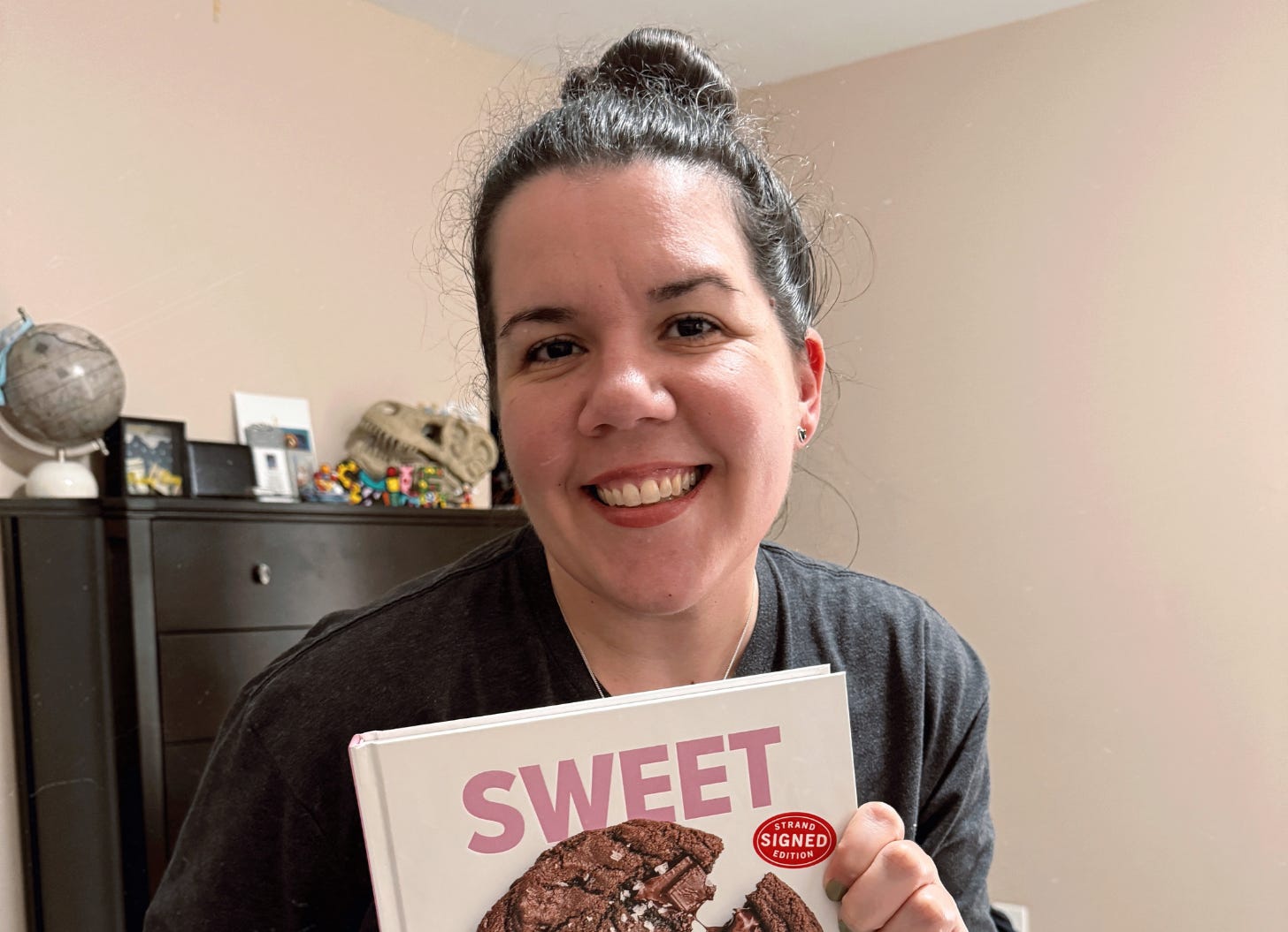 smiling holding my cookbook from Broma Bakery
