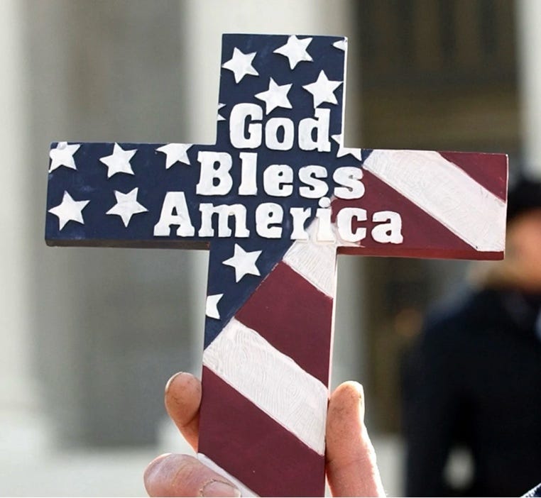 A hand holding a cross with a flag painted on it

AI-generated content may be incorrect.