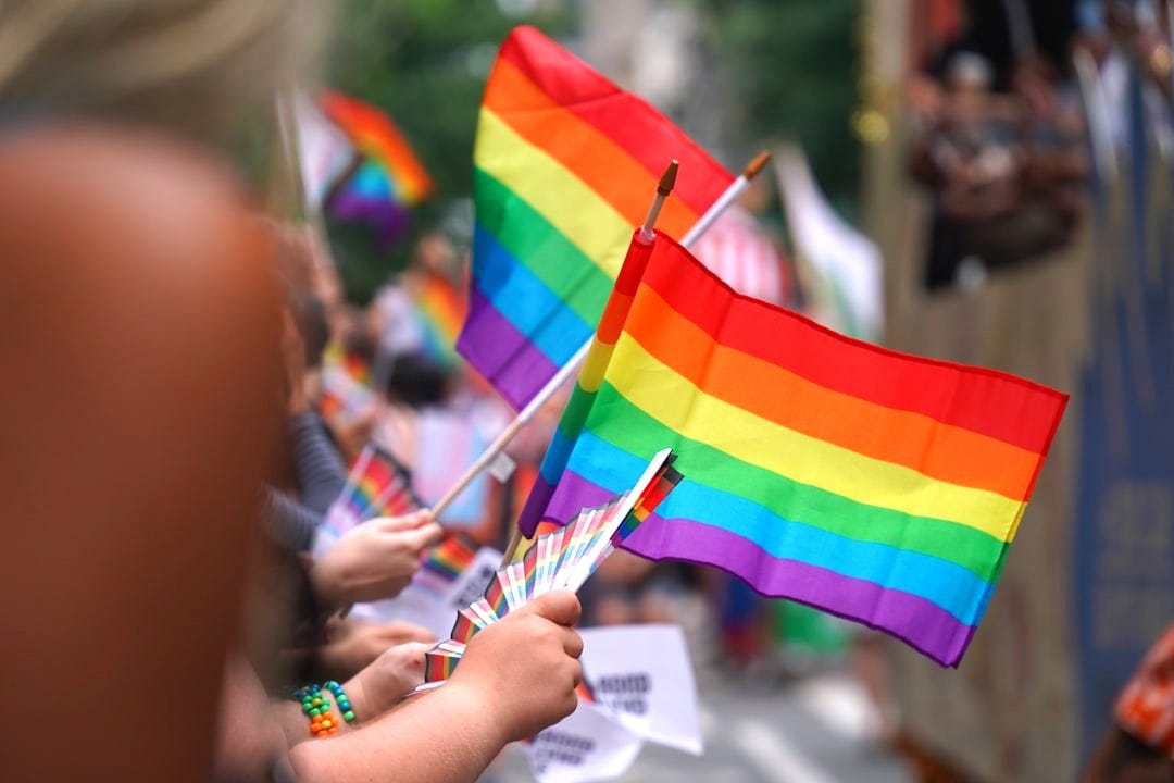 A group of people holding a rainbow flag A group of people holding a rainbow flag