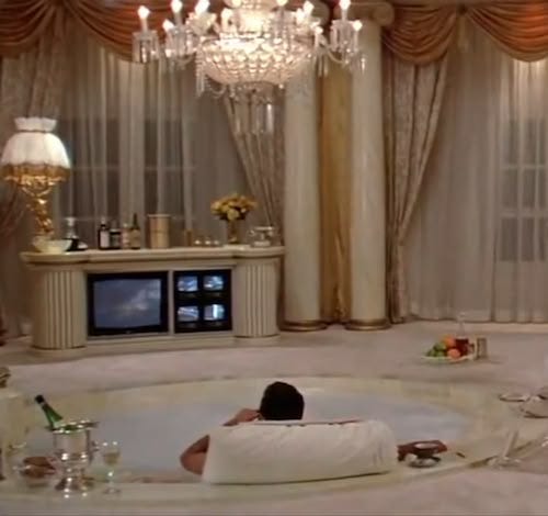 This may contain: a person laying in a hot tub with champagne on the table and chandelier