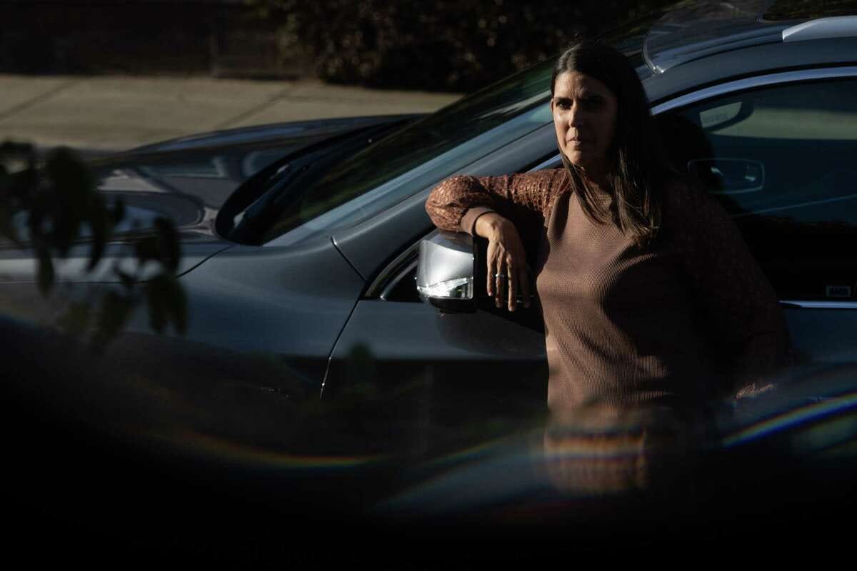 Christy Gagan poses for a portrait with her car outside her home in San Francisco on Tuesday, Oct. 10, 2023. Gagan had her Infiniti stolen and had to recover it herself after it was ticketed.