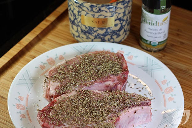 Herbes de Provence seasoned pork chops on a plate Herbes de Provence seasoned pork chops on a plate