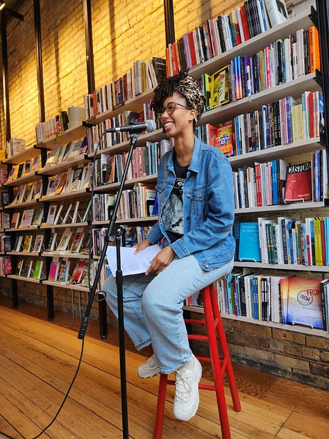 Various poets standing or sitting in Milkweed Bookstore, in front of filled bookcases, reading poetry.
