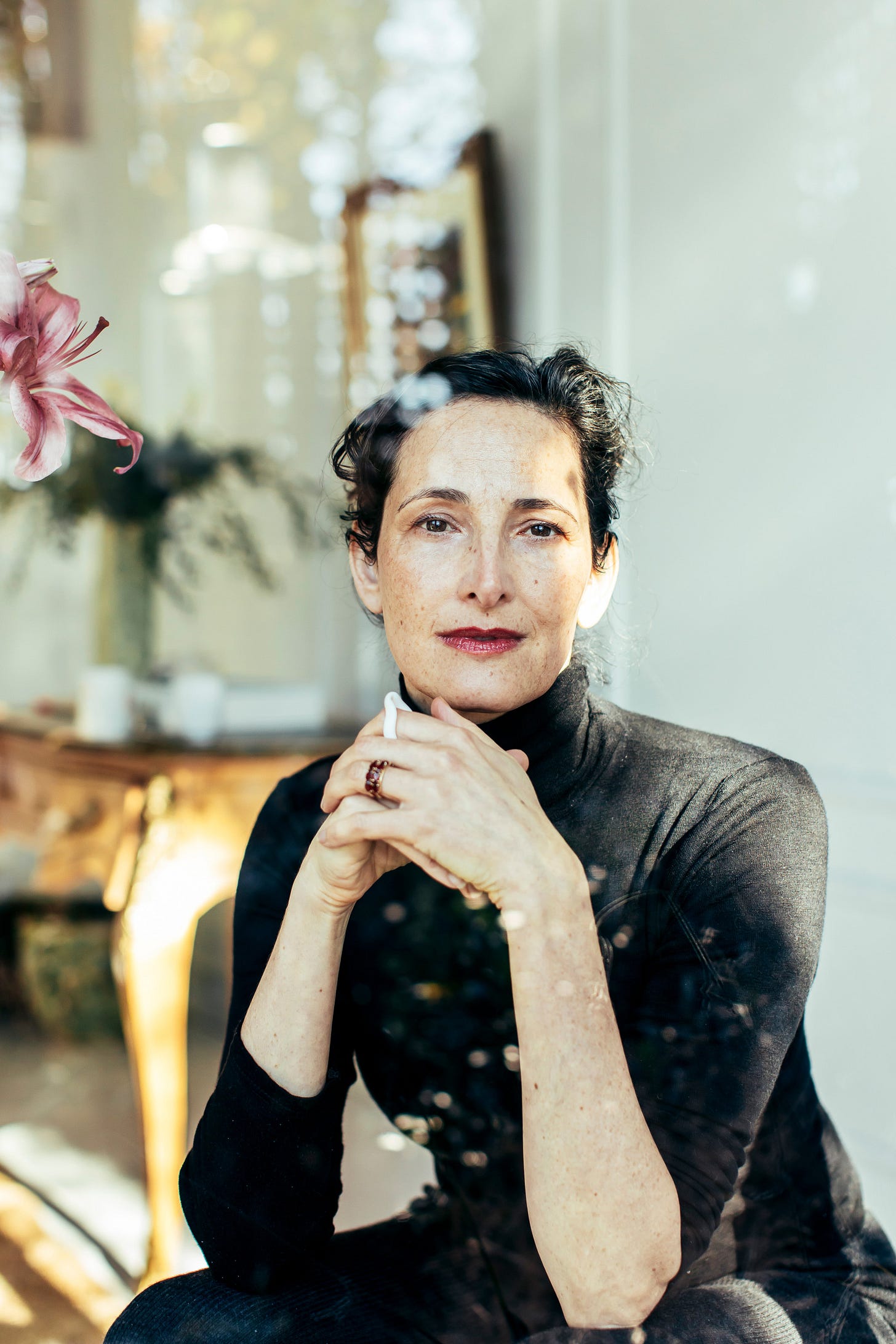 Dr Catherine sitting in her studio with sparkles all around