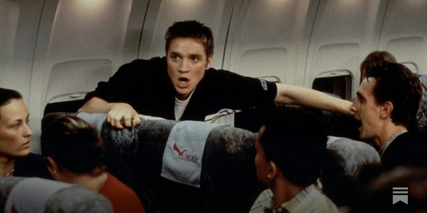 Devon Sawa on a plane, rising from his seat with his mouth wide open Devon Sawa on a plane, rising from his seat with his mouth wide open