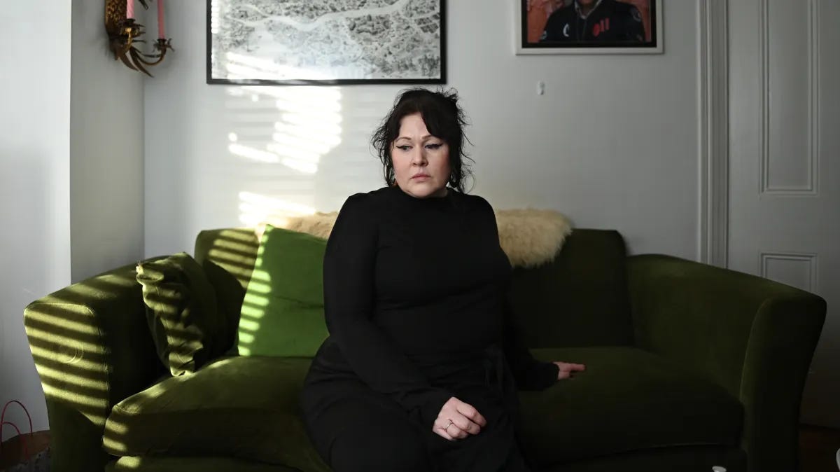 Sara Morrison sitting on a green sofa in her home in Belfast, Northern Ireland.