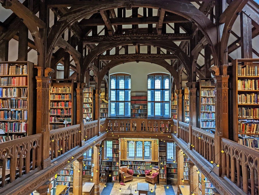 A shot from the top gallery of the Theology Room. It shows pillars, baulstrades, bookshelves and windows at the far end A shot from the top gallery of the Theology Room. It shows pillars, baulstrades, bookshelves and windows at the far end
