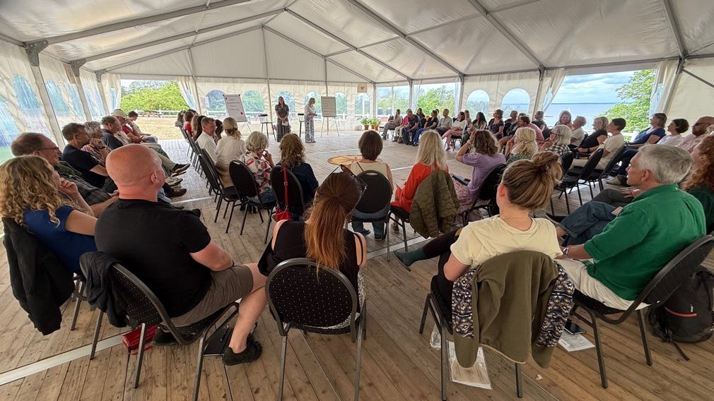 A group of people sitting in chairs in a tent

AI-generated content may be incorrect.