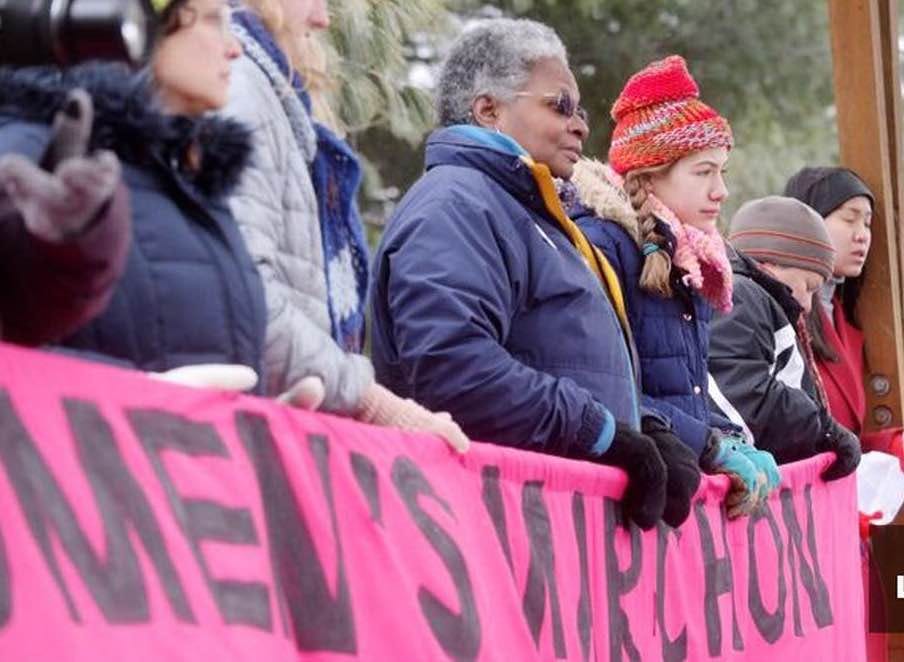 Mandy alongside young women holding a banner at the Asheville NC women's march.