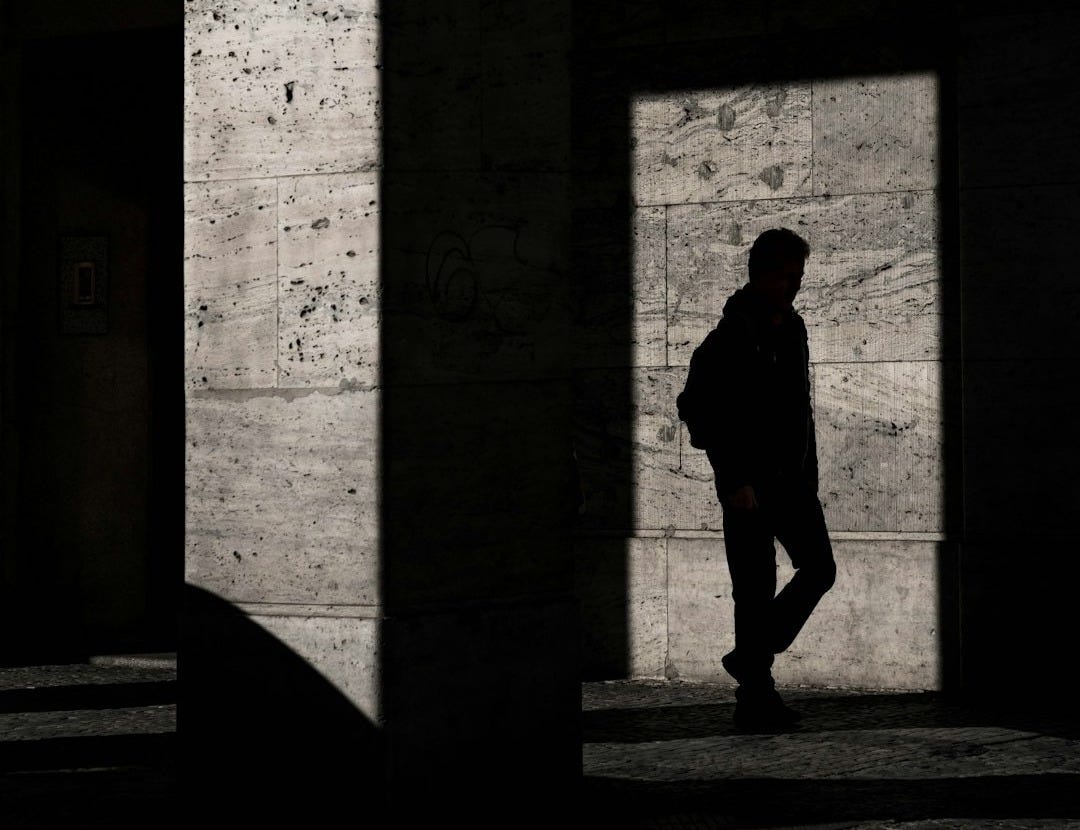 silhouette of man standing inside structure silhouette of man standing inside structure