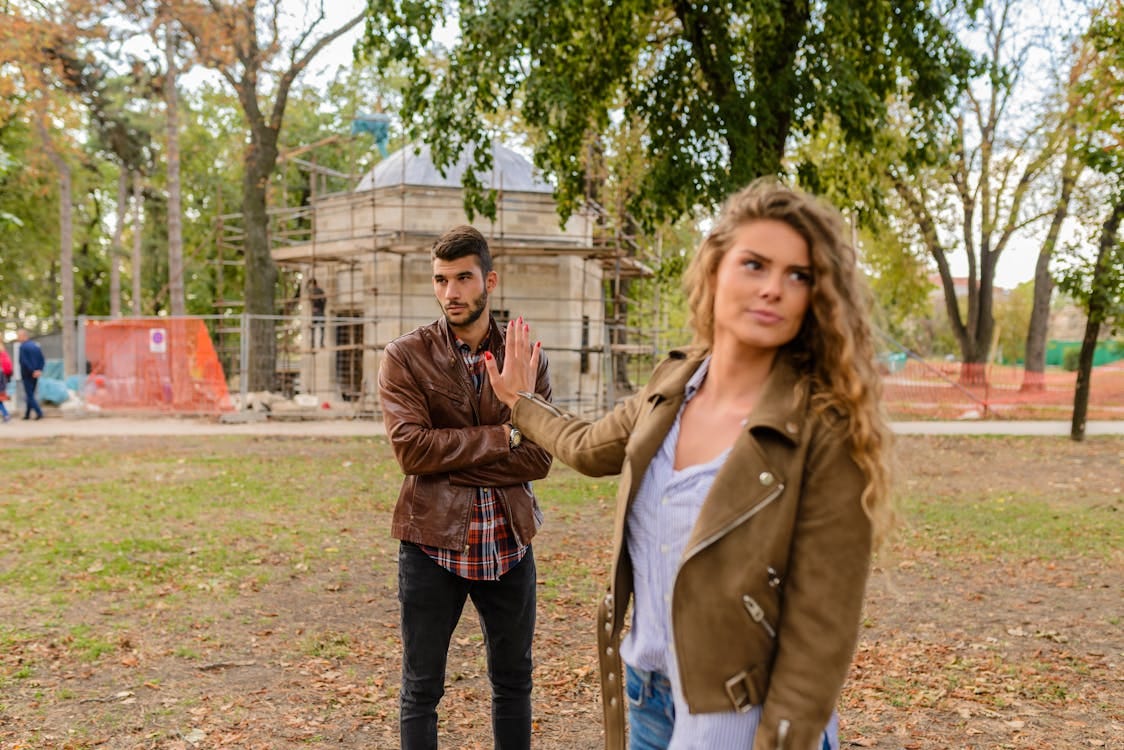 Free A couple faces disagreement outdoors in a park setting showcasing emotional expressions. Stock Photo Free A couple faces disagreement outdoors in a park setting showcasing emotional expressions. Stock Photo
