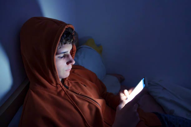 Teenager using a smartphone lying in bed late at night Teenager using a smartphone lying in bed late at night, playing games, watching videos online, and scrolling the screen. Children's screen addiction. Screen Addiction in Youth. boy phone screen stock pictures, royalty-free photos & images Teenager using a smartphone lying in bed late at night Teenager using a smartphone lying in bed late at night, playing games, watching videos online, and scrolling the screen. Children's screen addiction. Screen Addiction in Youth. boy phone screen stock pictures, royalty-free photos & images