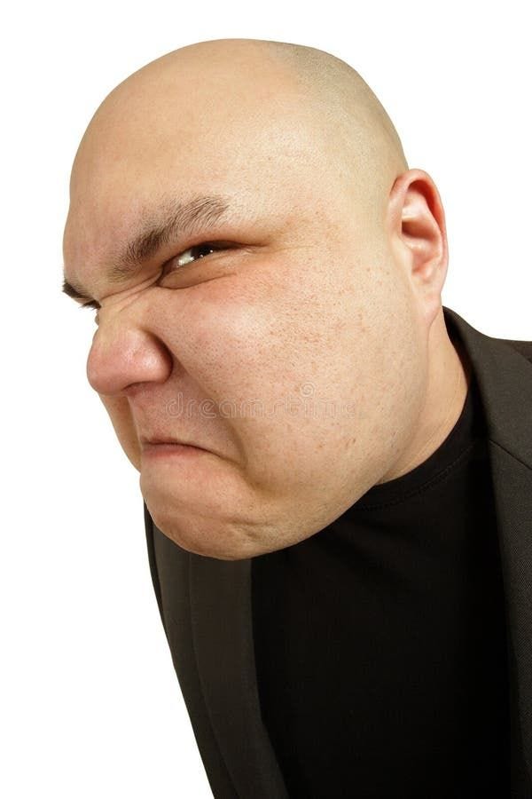 Angry sneer. A bald man with an angry threatening sneer or disgusted look on his face royalty free stock photo