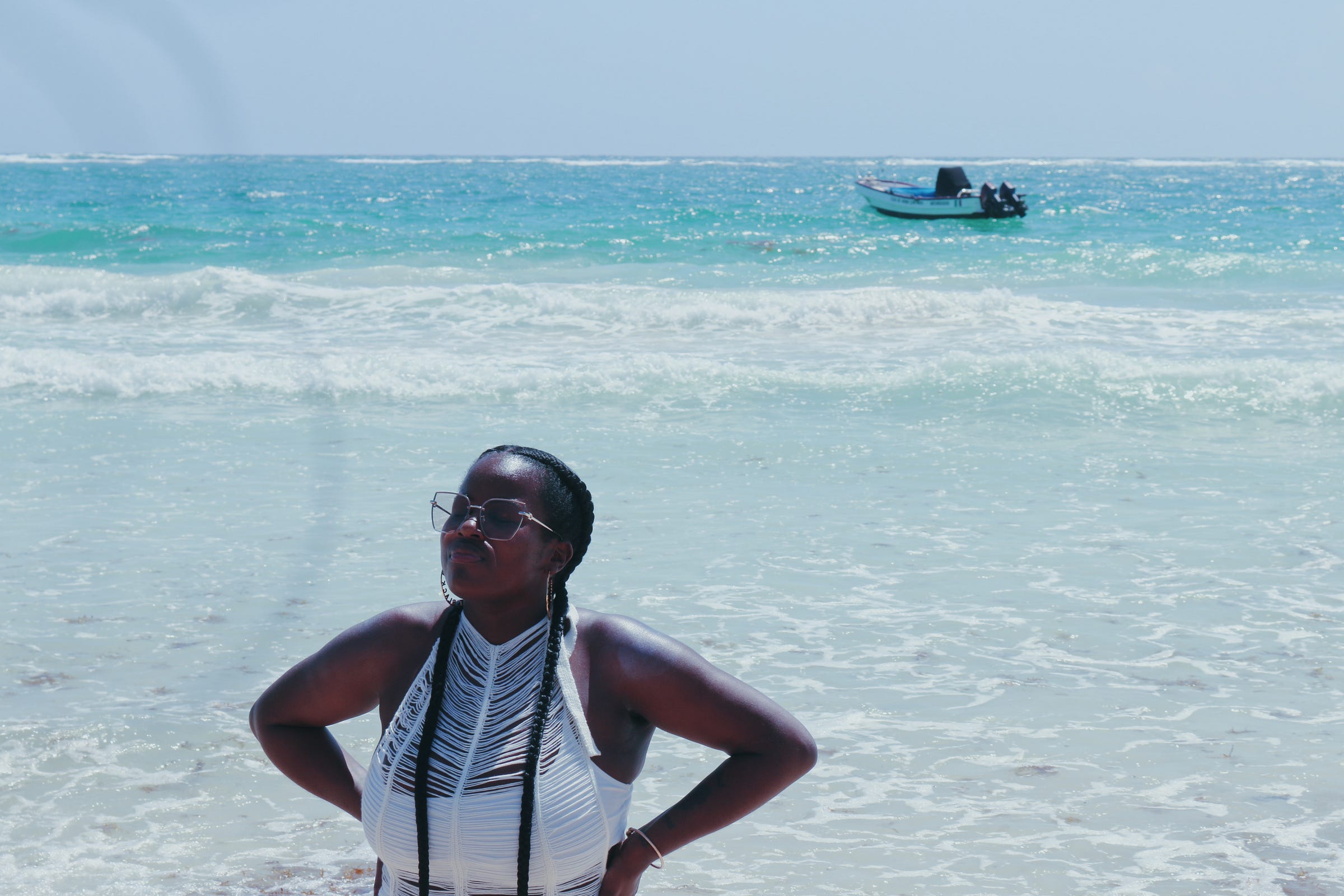Erica in prayer at a beach in Tulum, Mexico captured by Brandie Freely on February 2023