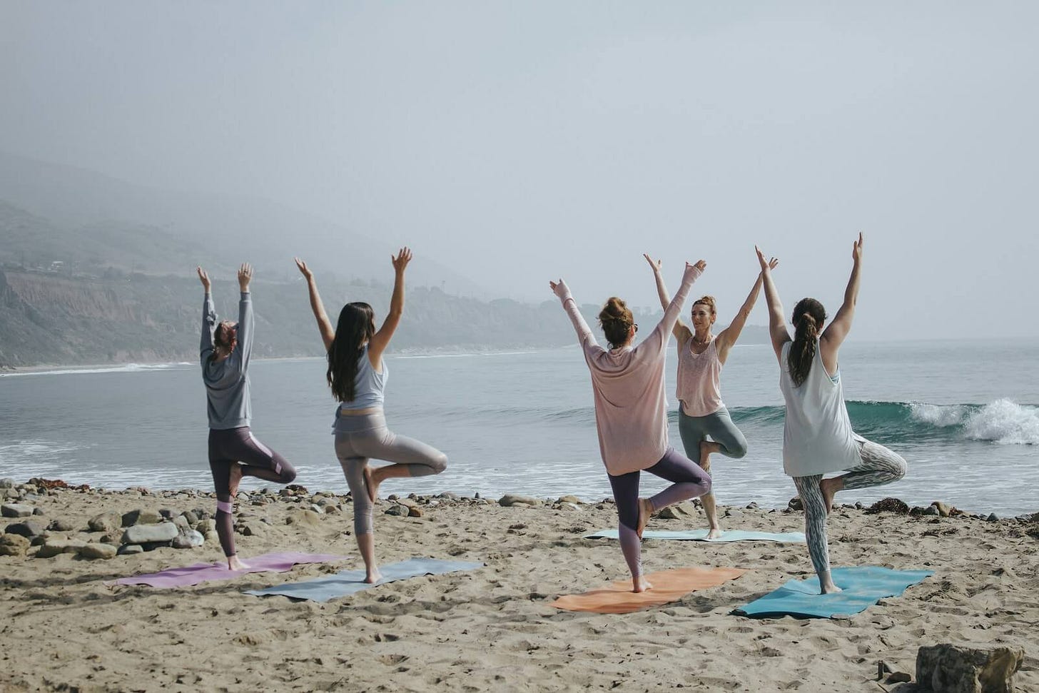 five woman in an exercise class on the beach