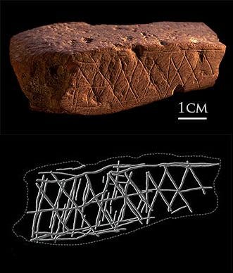 Ochre stone from Blombos Cave bearing repeated geometric engraved markings.
