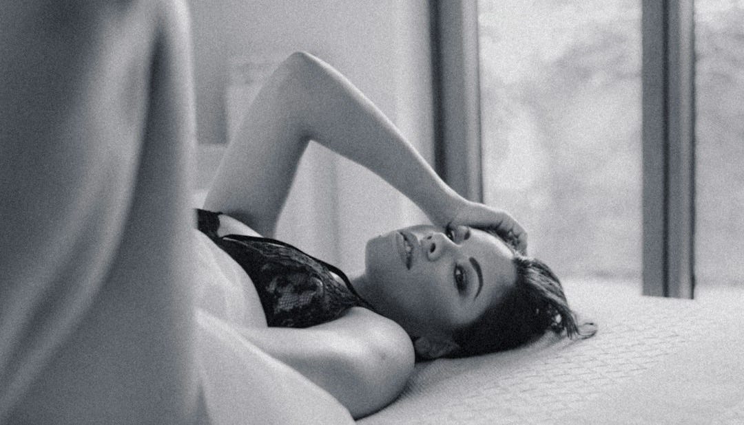 topless woman lying on bed