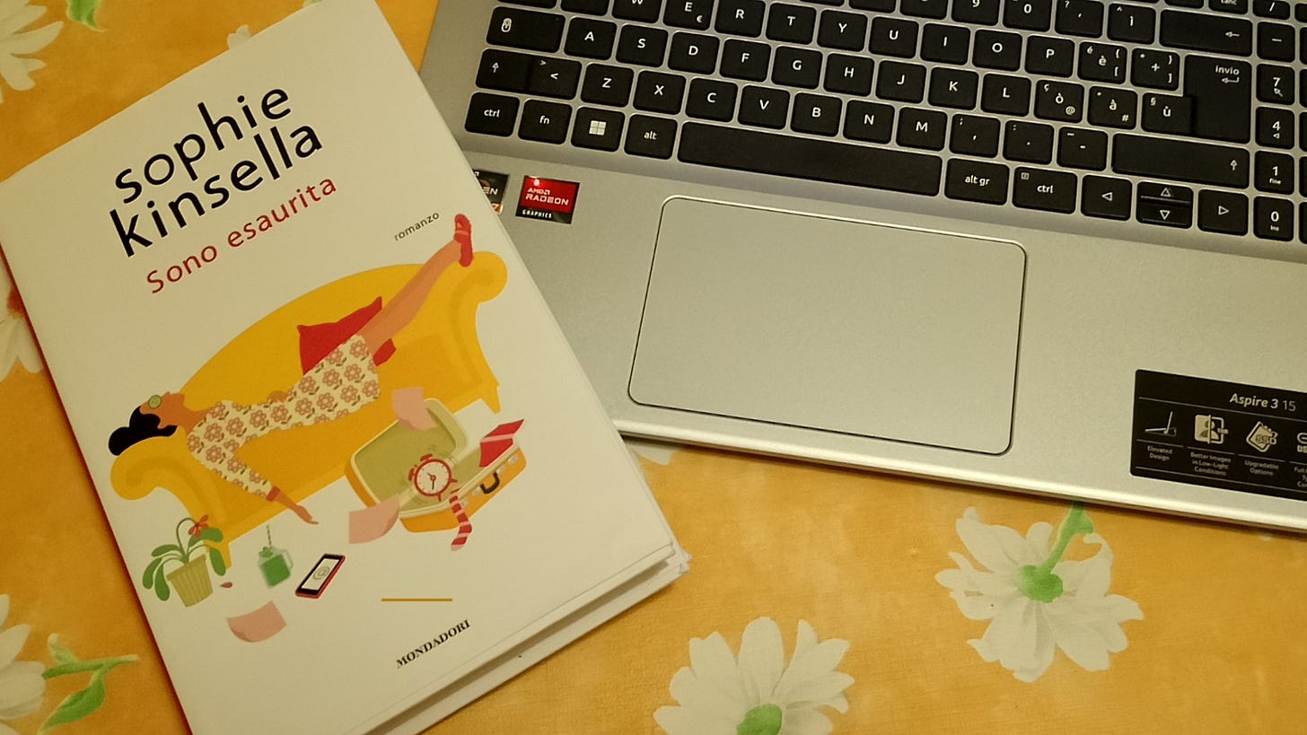 A copy of the Italian version of "The Burnout" by Sophie Kinsella next to a laptop