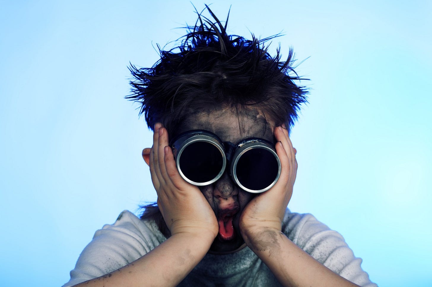 A kid covered in dirt with a face in shock