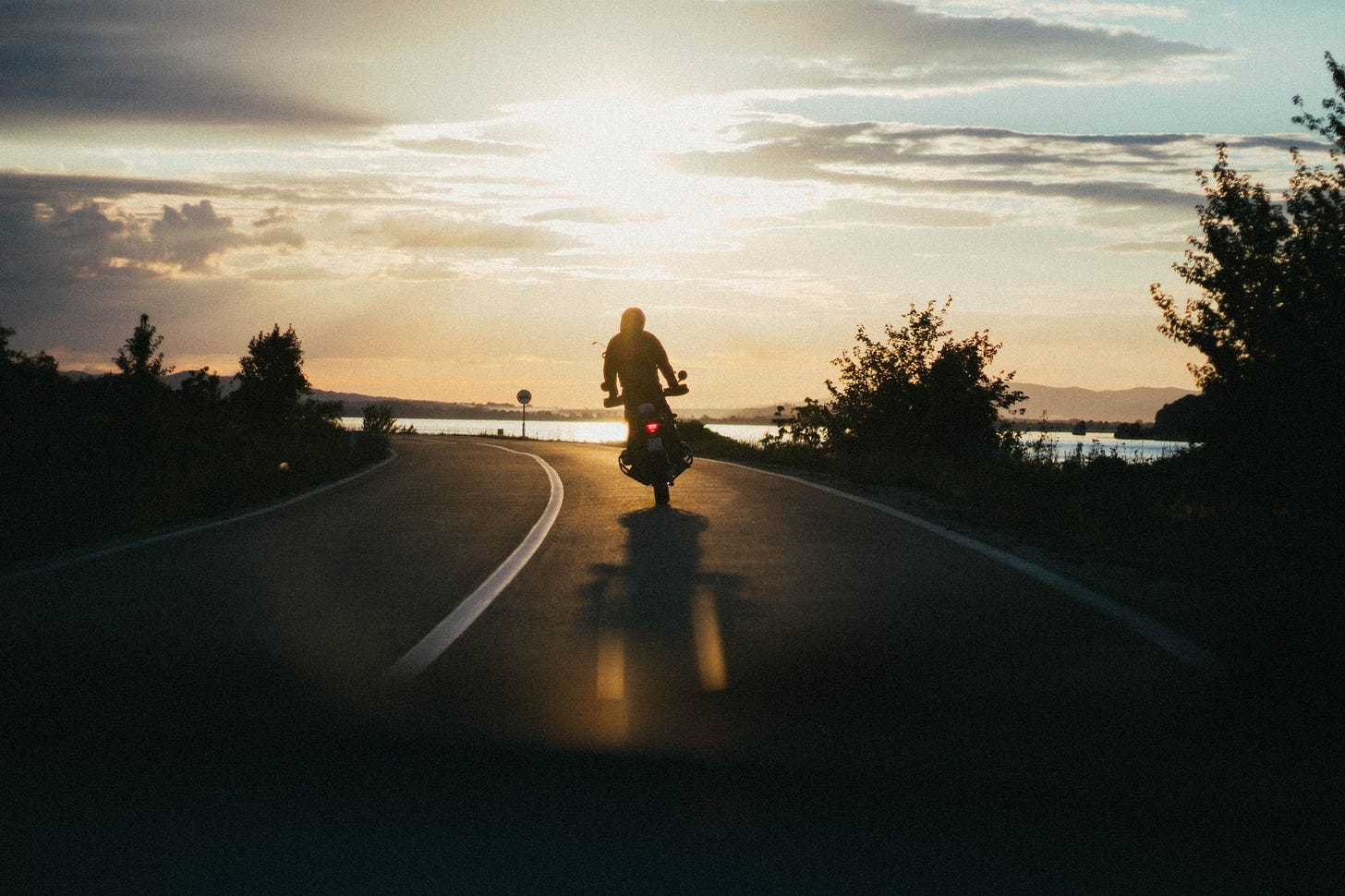 Someone riding a motorcycle at sunset. Someone riding a motorcycle at sunset.