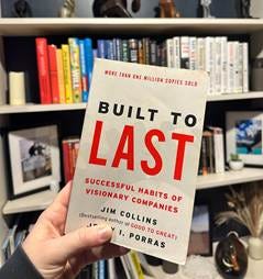 A hand holding a book in front of a bookshelf

AI-generated content may be incorrect.