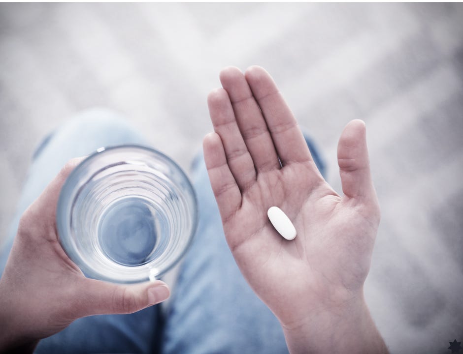 woman in blue jeans holding pill with glass of water woman in blue jeans holding pill with glass of water