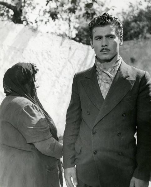 Scena del film "Due soldi di speranza" - Regia Renato Castellani, 1952 - A  destra, Vincenzo Musolino guarda dritto davanti a sé, affiancato da  un'attrice non identificata a capo coperto. – Fotografie –