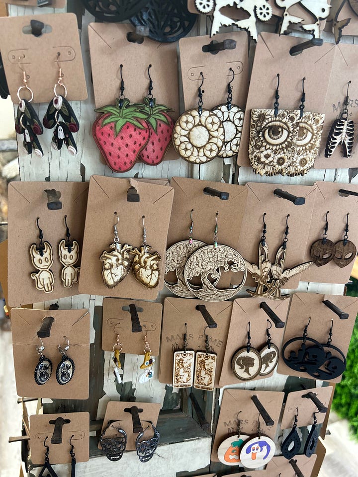 Collage of five images including a tattoo chair, women's clothing mannequin, display of earrings, greenery wall in a craft room, and small room with a sign that says "tarot".
