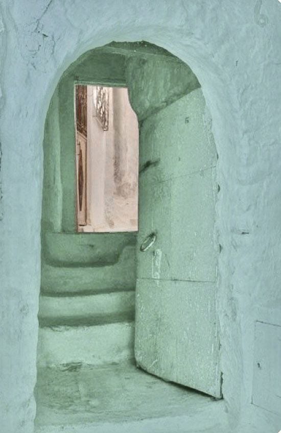 This may contain: an open doorway leading into a room with green paint on the walls and steps in front of it
