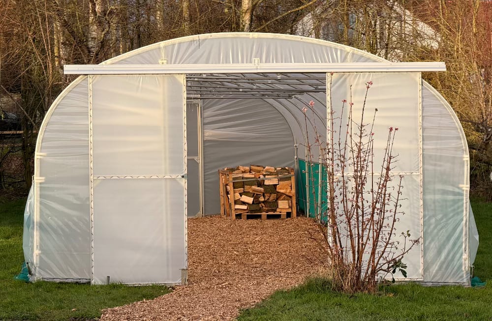 a polytunnel with a wood chip floor