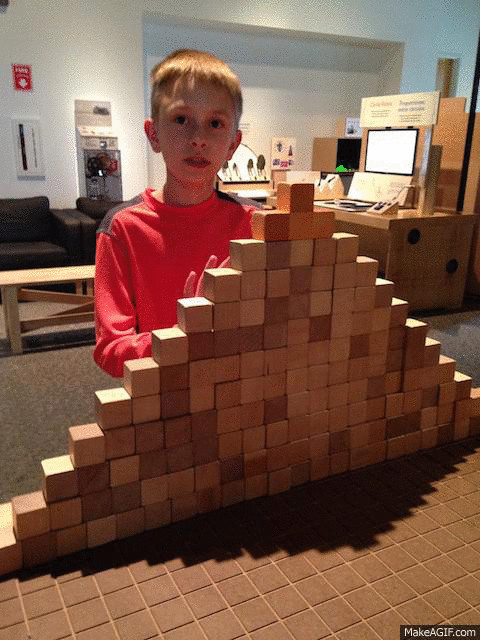 An animation of a boy knocking down a wall made of building blocks An animation of a boy knocking down a wall made of building blocks