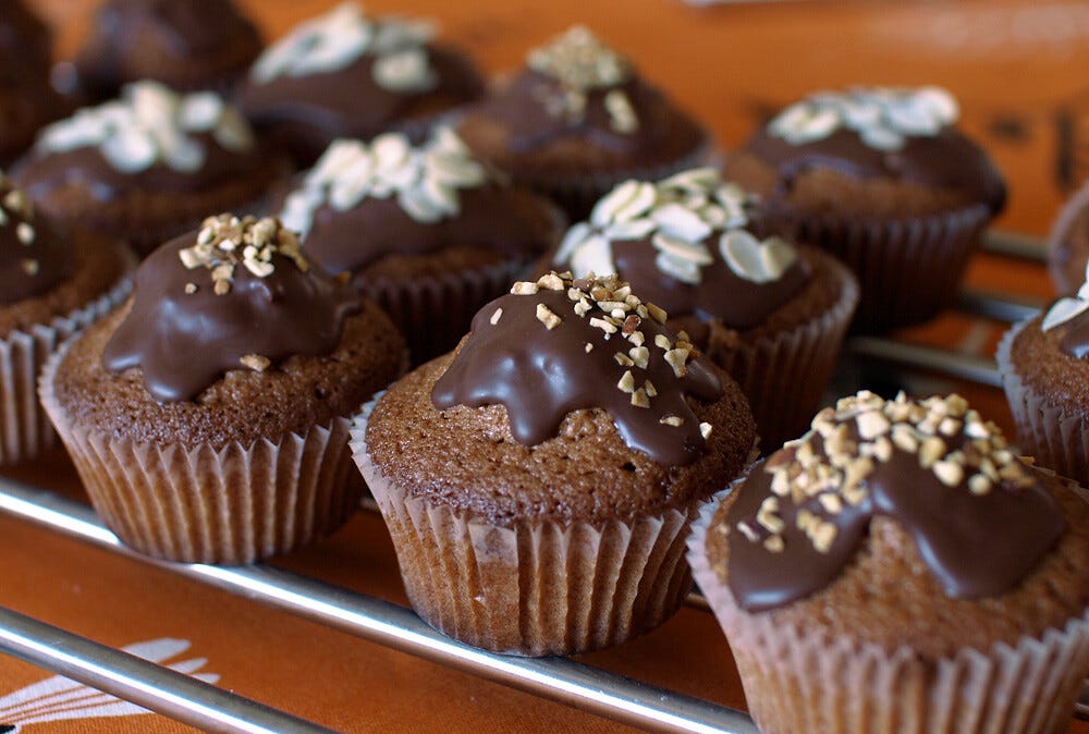A batch of muffins with chocolate frosting and chopped nuts on top. "Chocolate muffins" by Roberta Romagnoli / wererabbit is licensed under CC BY-NC-ND 2.0 A batch of muffins with chocolate frosting and chopped nuts on top. "Chocolate muffins" by Roberta Romagnoli / wererabbit is licensed under CC BY-NC-ND 2.0