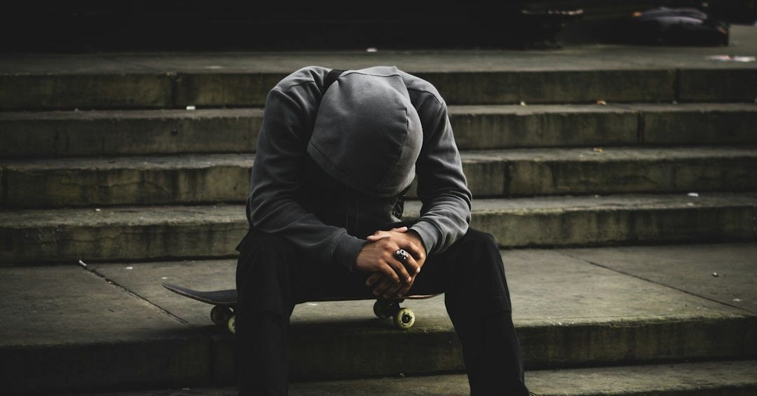 a man sitting on some steps with his head in his hands