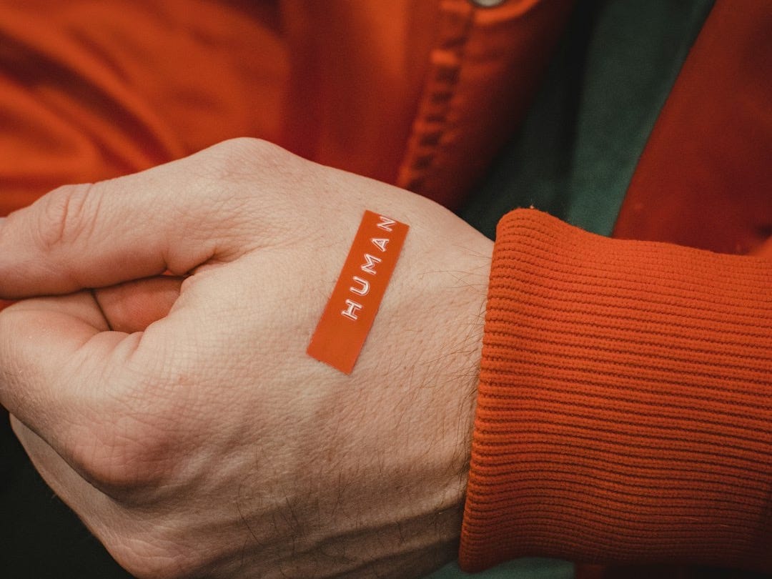 orange and white textile on persons hand orange and white textile on persons hand