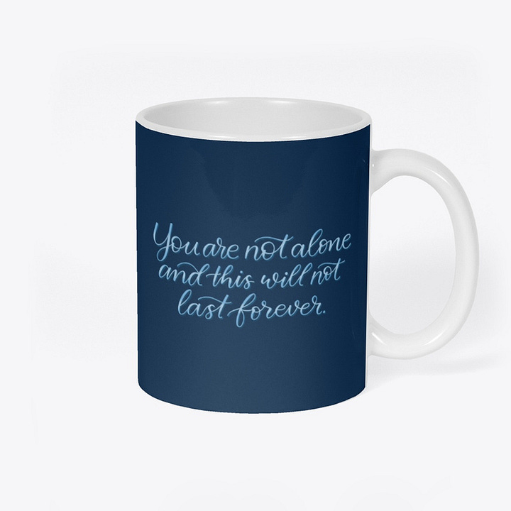 a sticker and a mug, both navy blue with light blue text that reads "you are not alone and this will not last forever"