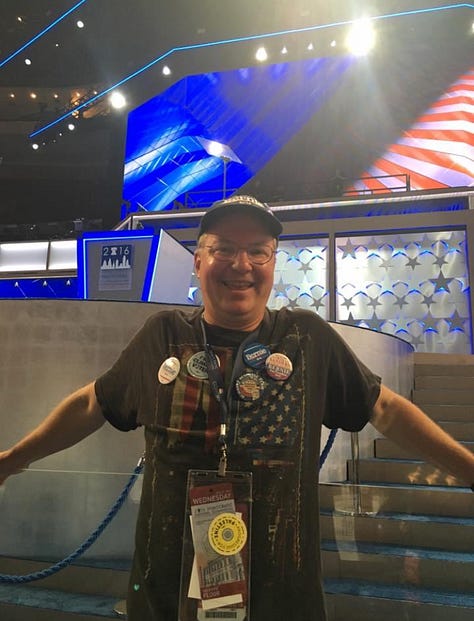 Kacey Carpenter holding signs, wearing shirts, buttons, and voting for Bernie Sanders as DNC delegate in Philly in 2016