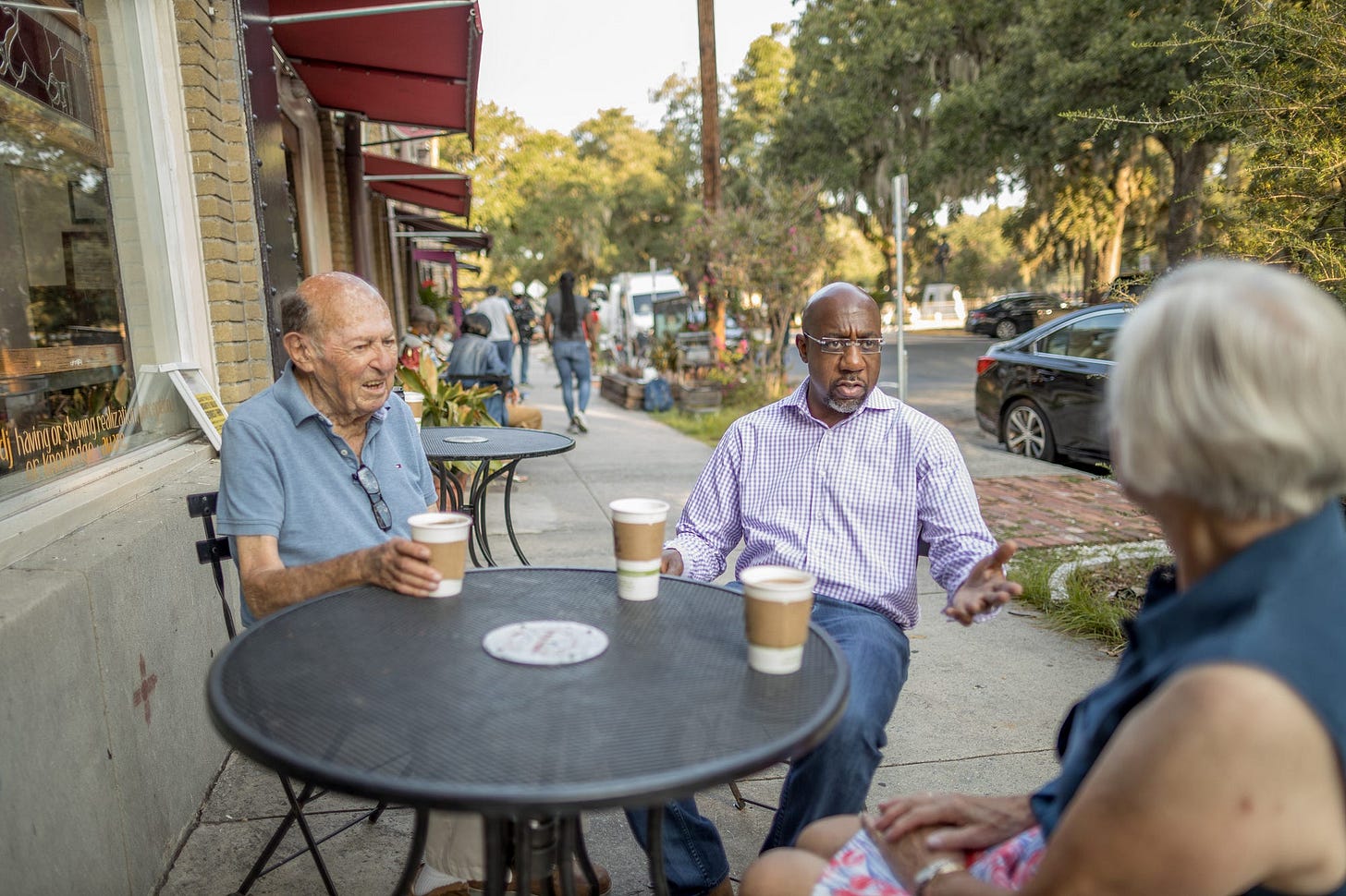 Raphael Warnock meeting at an outdoor café with local white constituents Raphael Warnock meeting at an outdoor café with local white constituents