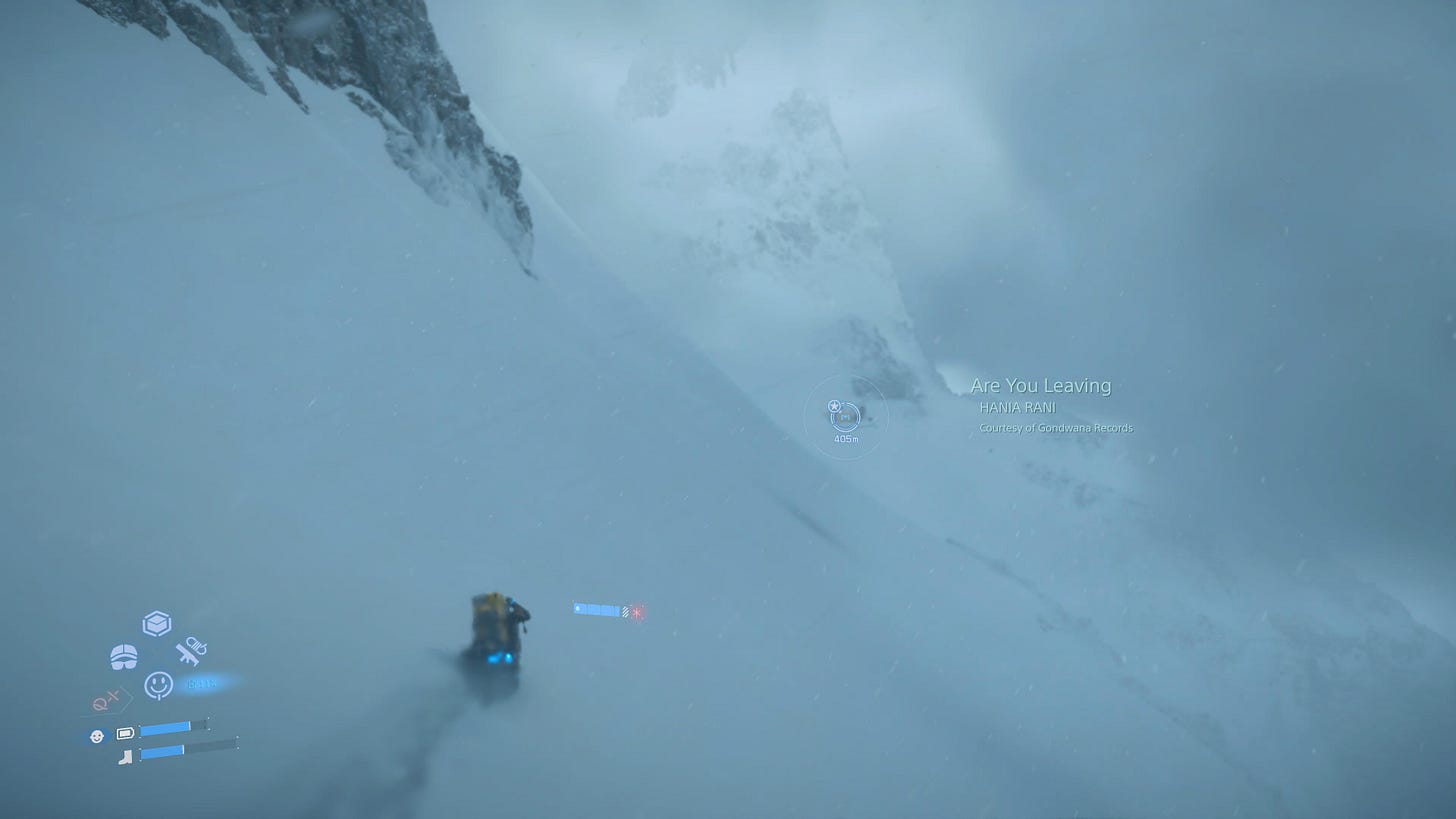 Sam walks on the side of a snowy mountain. There is a haze of snow.