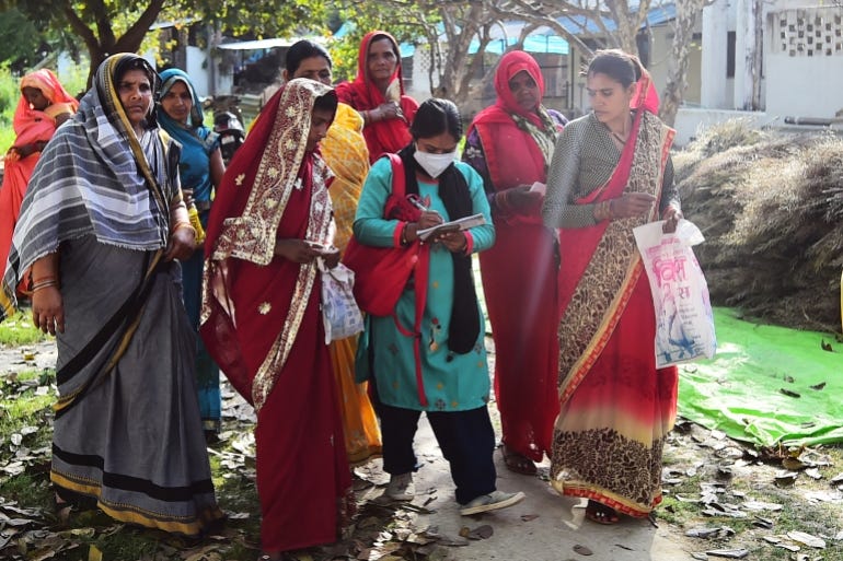 In this picture taken on March 11, 2022, Meera Devi (C), managing editor and reporter of "Khabar Lahariya" (Waves of News), speaks to village women while reporting in Banda district, Uttar Pradesh state. - An all-women team of smartphone-toting, low-caste reporters who chronicle India's hardscrabble heartland may give the cinema-mad country its first Oscar-winning film, after their own story became a critically lauded documentary. (Photo by SANJAY KANOJIA / AFP) / TO GO WITH India-social-media-film-oscar,FOCUS by Abhaya SRIVASTAVA