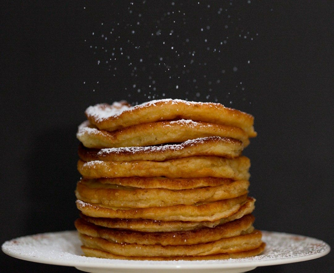 a stack of pancakes covered in powdered sugar