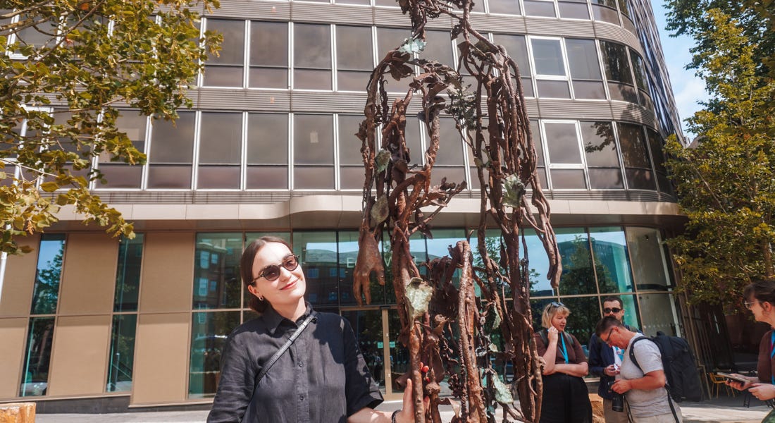A woman - Alicja Biala - wearing a black dress and posing with the Maid Marian statue A woman - Alicja Biala - wearing a black dress and posing with the Maid Marian statue
