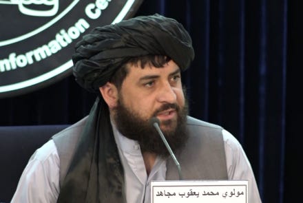 A person wearing a hat and holding a microphone

Description automatically generated with low confidence