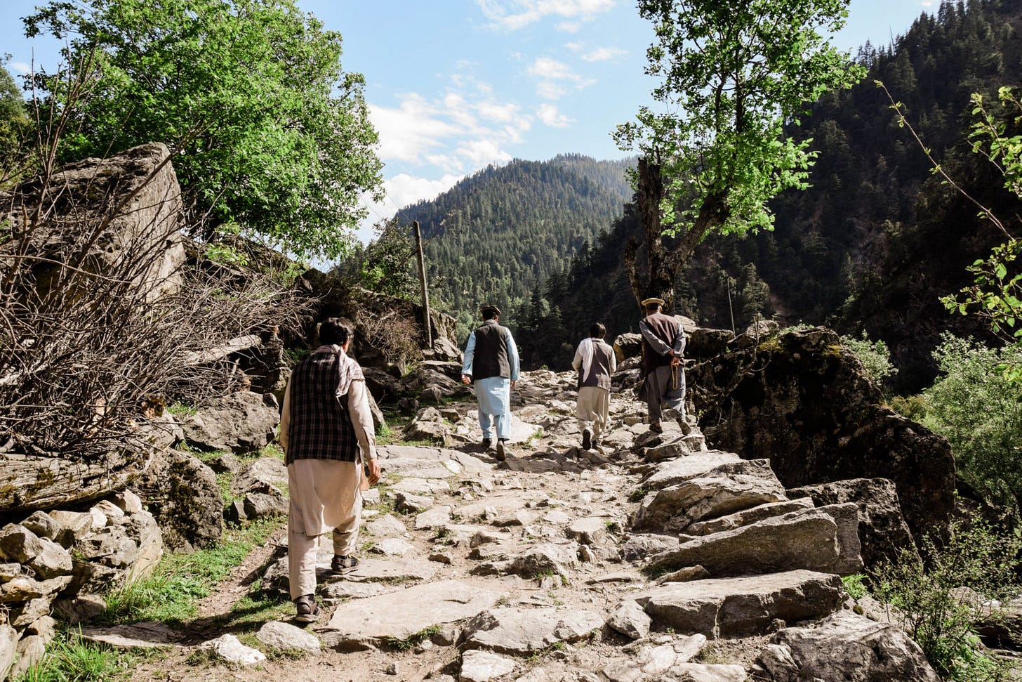 A group of people walking on a rocky path

Description automatically generated with low confidence