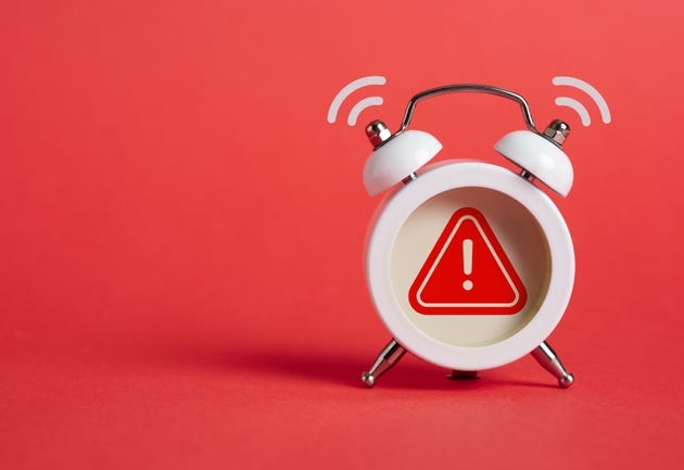 Caution, warning or exclamation sign inside of an alarm clock. Caution, warning or exclamation sign inside of an alarm clock.