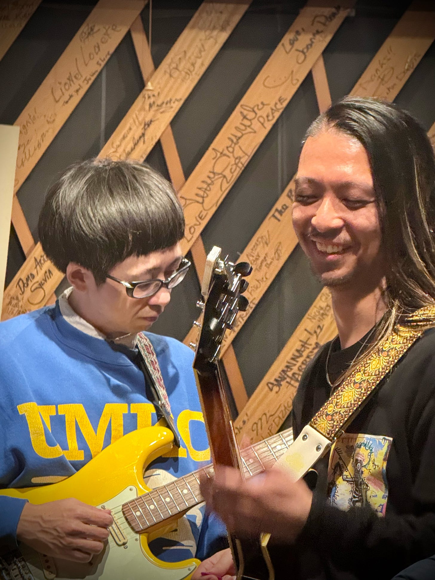 A person holding a guitar next to a person

AI-generated content may be incorrect.